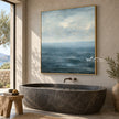 Blue Sea and Soft Cloud Horizon Wall Art shown above a freestanding bathtub.