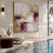 Cream and Plum Weathered Abstract Painting shown in a poolside interior.