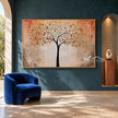 Golden Leaf Tree on a Peach Background Wall Art shown above a blue chair and a blue-fronted console.