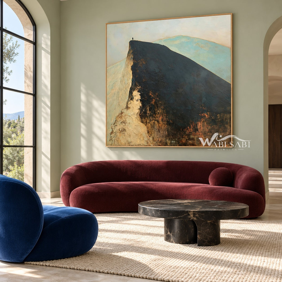 Lone Figure on a Broad Mountain Ridge Wall Art shown above a burgundy sofa.