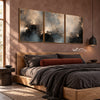 Misty Blue and Charcoal Landscape Triptych shown above a bed with dark bedding.