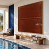 Rust Red Field with a Fine Seam Wall Art shown above a long wood bench.