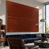 Rust Red Field with a Fine Seam Wall Art shown above a dark blue sofa.