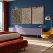 Taupe Texture Study Triptych Wall Art shown above a bed beside a yellow chair.