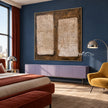 Two Cream Blocks on Brown Abstract Wall Art shown above a bed beside a yellow chair.