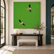 Two Flying Birds on Bright Green Wall Art shown above a dark console.