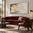 White Blossoms across a Golden Circle Wall Art shown above a burgundy sofa.