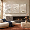 White Folded Ridges Triptych Wall Art shown near a fireplace.