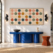Wide Multicolor Painted Dot Grid Wall Art shown above a blue console between wall lights.