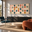 Wide Multicolor Painted Dot Grid Wall Art shown above a dark cabinet in a bright seating area.